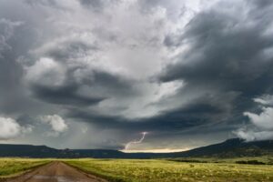 huge New Mexico sky with dark, threatening storm clouds and a lonely dirt road. If loneliness, feeling angsty, worried, full of despair is getting you down, reach out for counseling with the Santa Fe Therapist. Online therapy in New Mexico. 87122, 87506, 87048