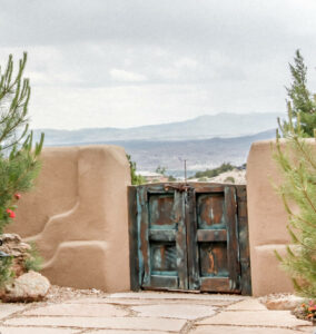 Adobe wall with a closed wooden gate overlooks a large valley with distant mountains in New Mexico. Possibilities and choices are limited or closed down when you're feeling too stressed. Stress management counseling w/ the Santa Fe therapist can help. 87544, 87122, 87506, 87048, 87501